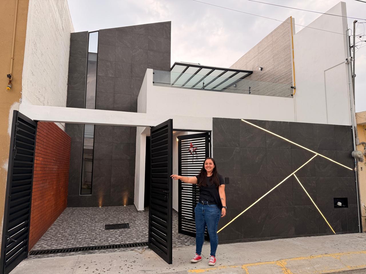 Una de las arquitectas de Estudio Trece junto a la fachada terminada de Casa Maestra